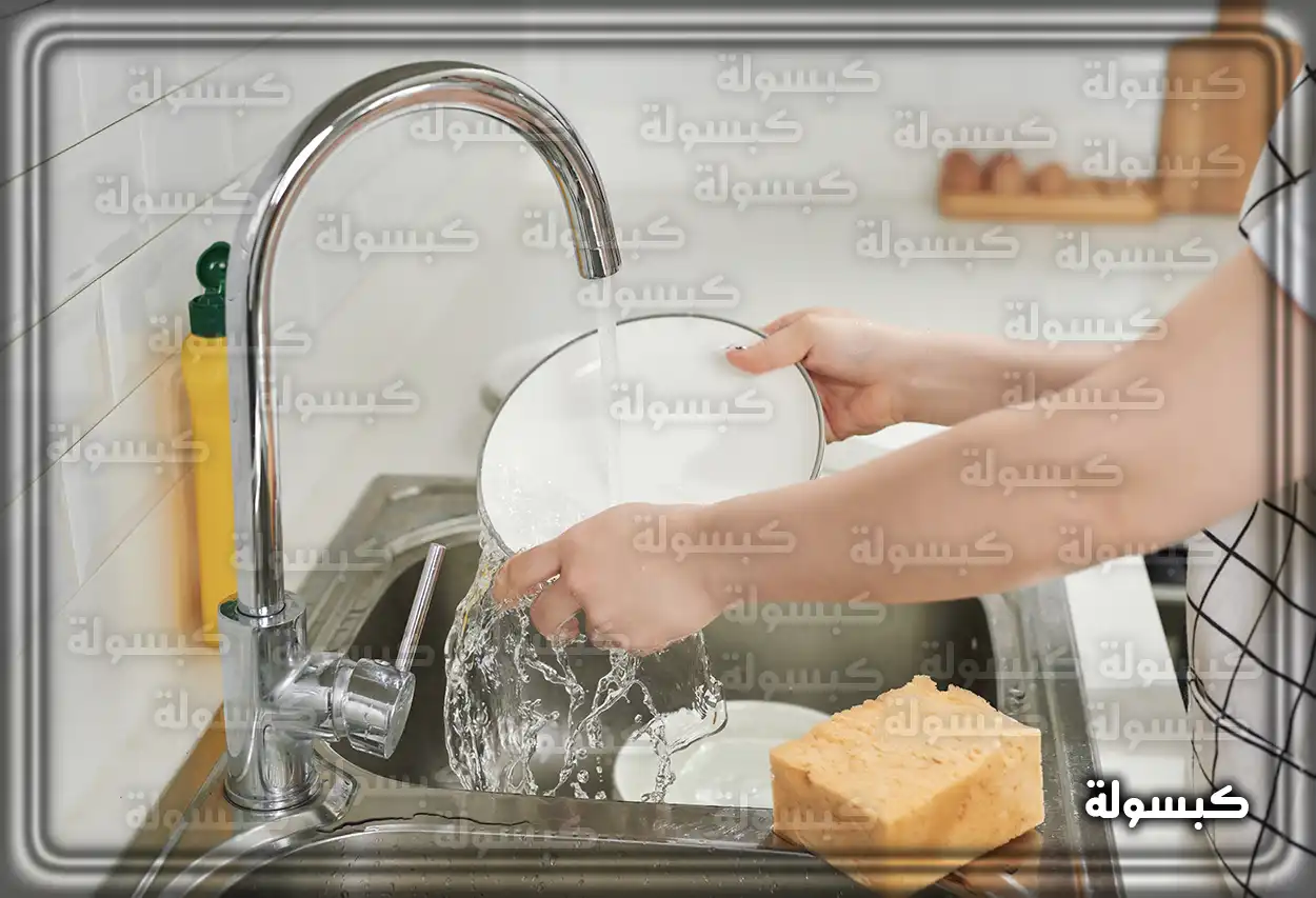 شخص يغسل الأطباق في حوض المطبخ