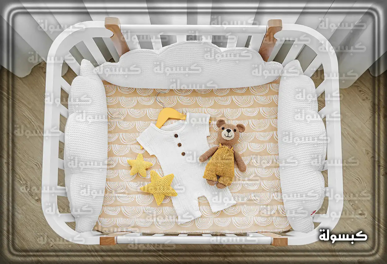 سرير طفل أبيض في غرفة نوم كرمز للأمومة في المنام