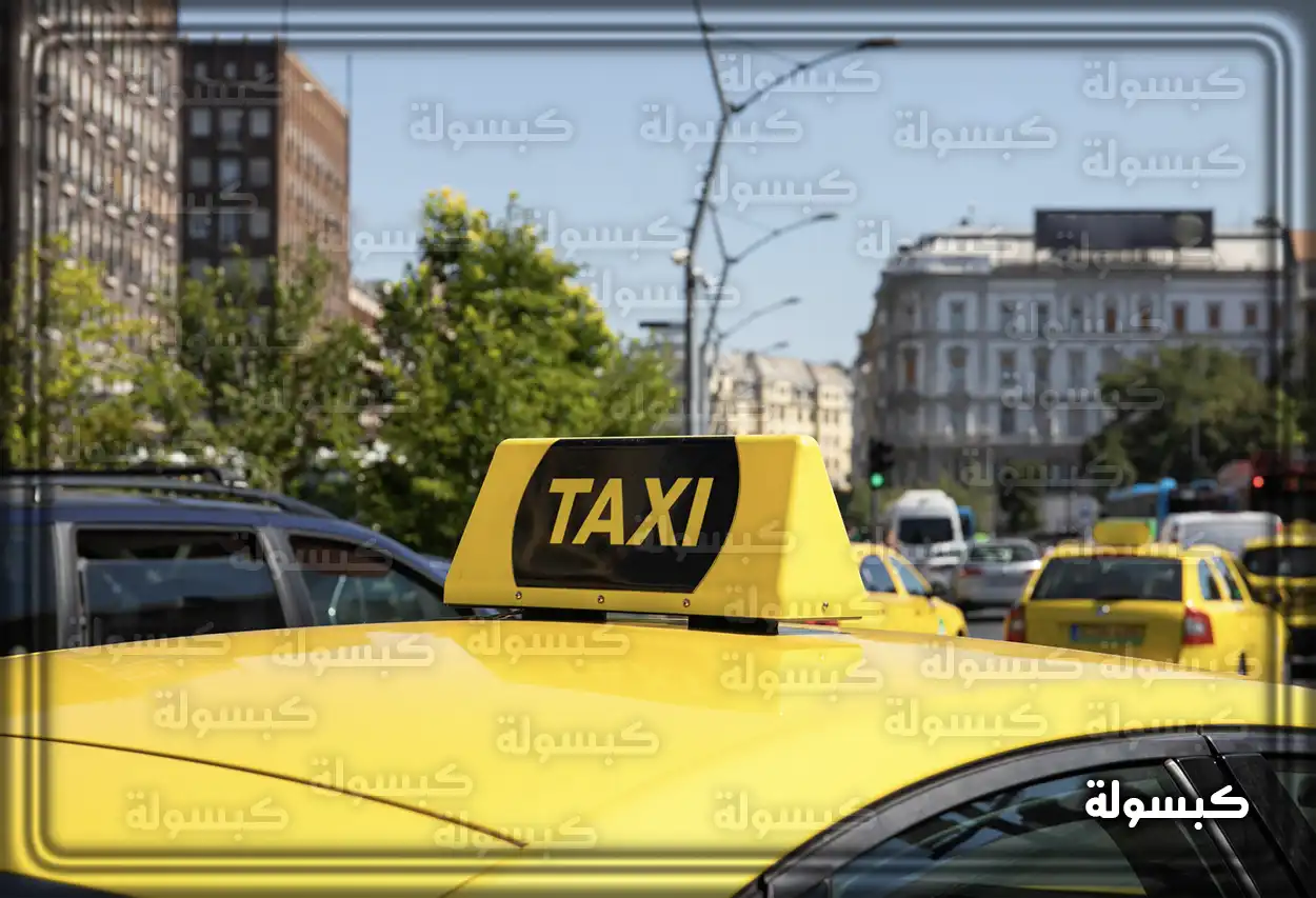 سيارة تاكسي صفراء تسير في المدينة ليلاً